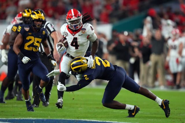 Georgia Bulldogs running back James Cook (4) runs the ball against the Michigan Wolverines during the first quarter in the Orange Bowl college football CFP national semifinal game at Hard Rock Stadium.