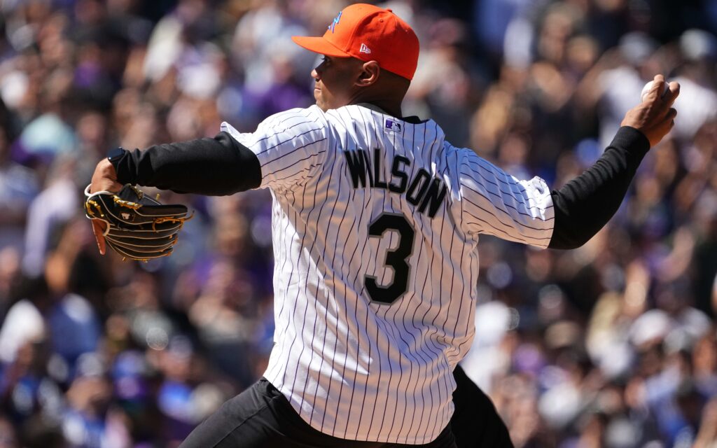 Russell Wilson pitches at Coors Field. Credit: Ron Chenoy, USA TODAY Sports.