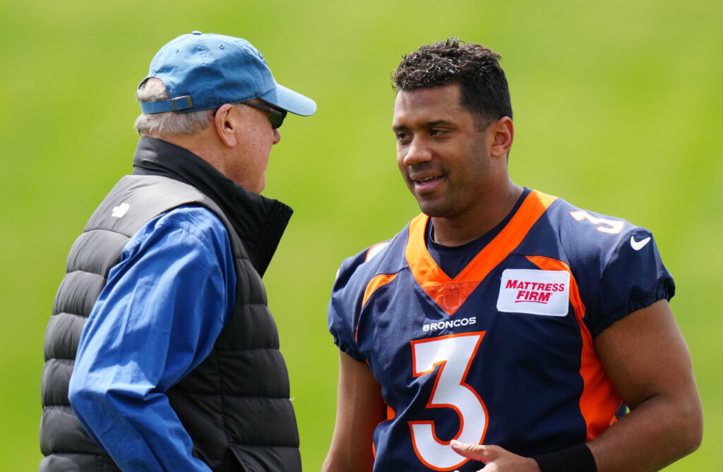 quarterback Russel Wilson (3) speaks to Paul Hackett father of head coach of the team during OTA workouts at the UC Health Training Center.