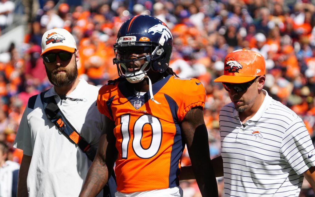 Jerry Jeudy helped off the field by trainers on Sunday, Sept. 18 at Empower Field at Mile High Stadium in Denver. Credit: Ron Chenoy, USA TODAY Sports.