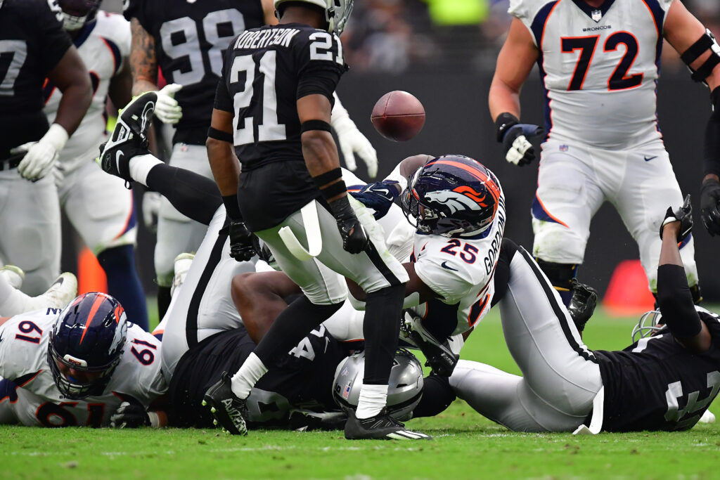 Denver Broncos running back Melvin Gordon III (25) loses the ball against the Las Vegas Raiders during the first half at Allegiant Stadium.