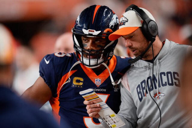 Denver Broncos quarterback Russell Wilson (3) talks with quarterbacks coach Klint Kubiak in the second quarter against the San Francisco 49ers at Empower Field at Mile High.