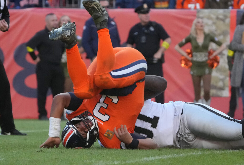 Las Vegas Raiders defensive tackle Bilal Nichols (91) tackles Denver Broncos quarterback Russell Wilson (3) in the second quarter at Empower Field at Mile High.