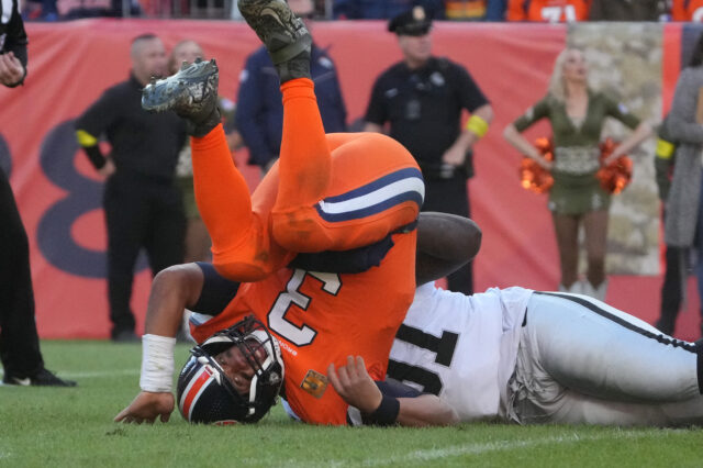 Las Vegas Raiders defensive tackle Bilal Nichols (91) tackles Denver Broncos quarterback Russell Wilson (3) in the second quarter at Empower Field at Mile High.