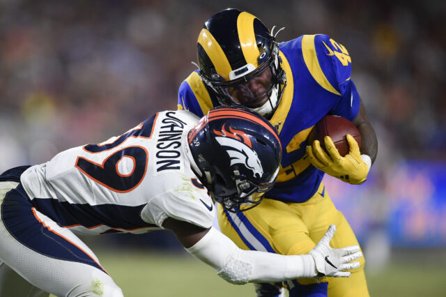 Los Angeles Rams running back John Kelly (42) runs the ball while Denver Broncos corner back Trey Johnson (39) defends during the second half at Los Angeles Memorial Coliseum.