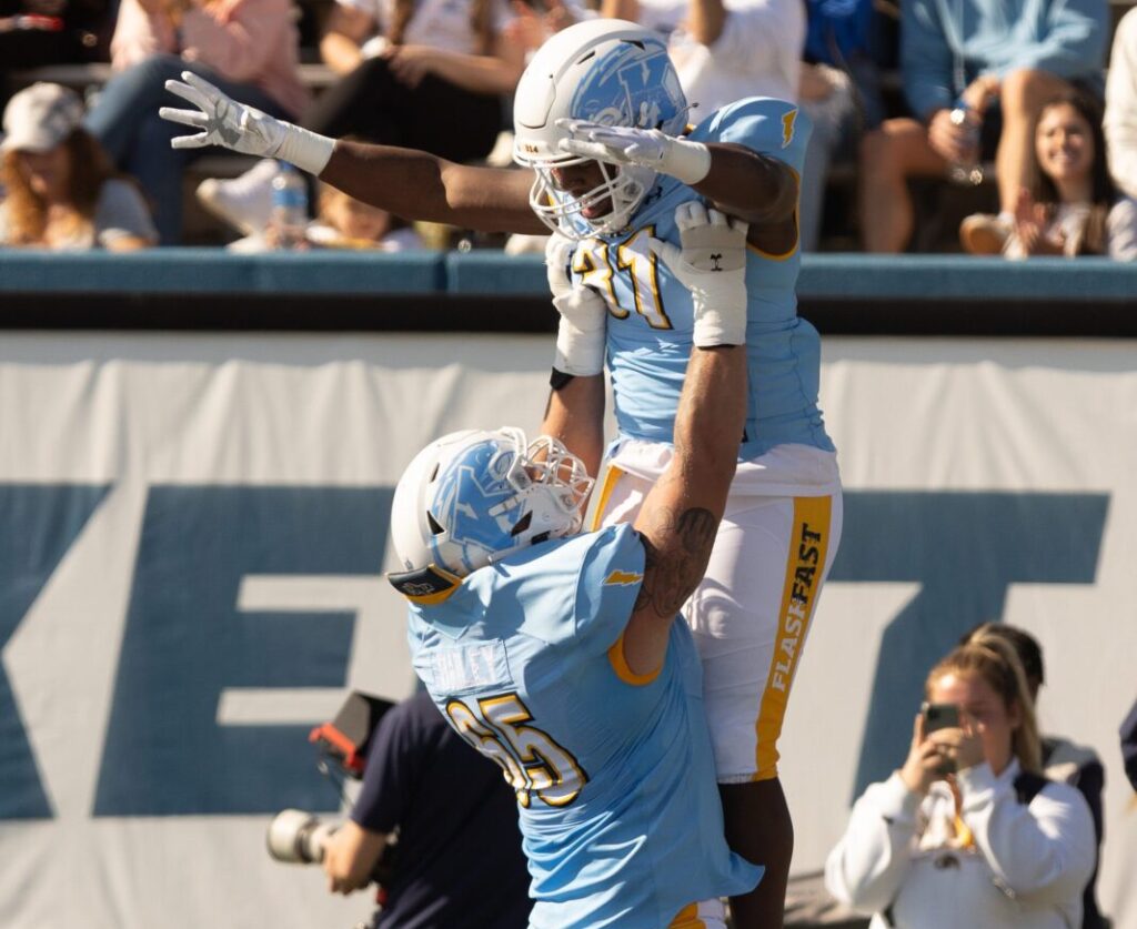 CU Buffs (Colorado Buffaloes) offensive lineman Jack Bailey lifts running back Bryan Bradford into the air after Bradford’s touchdown run in the first half of Saturday’s game against the Akron Zips at Dix Stadium.