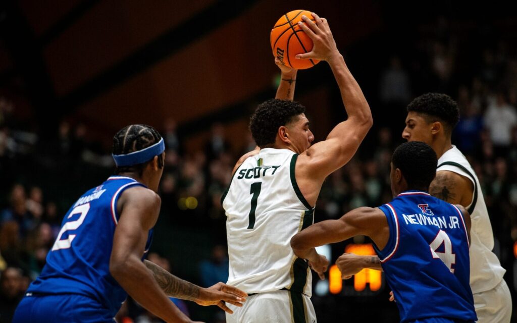 Joel Scott in game one with Colorado State, holding the ball away from two Louisiana Tech defenders.