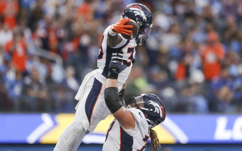 Quinn Meinerz lifts Javonte Williams in a touchdown celebration.