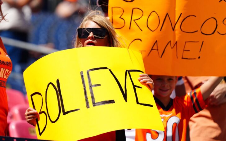 A fan holds a "BOLIEVE" sign at Broncos - Cardinals in 2024 preseason.