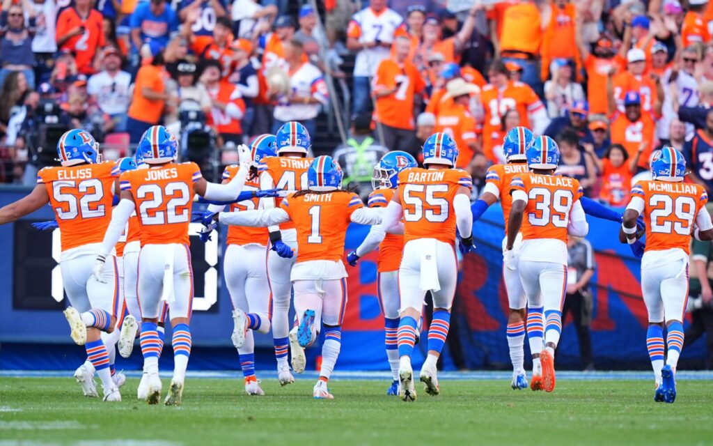 Denver Broncos celebrate a turnover in their throwback uniforms.