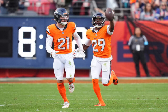 Denver Broncos cornerback Ja'Quan McMillian (29) celebrates his turnover with cornerback Riley Moss (21) in the second half against the Carolina Panthers at Empower Field at Mile High.