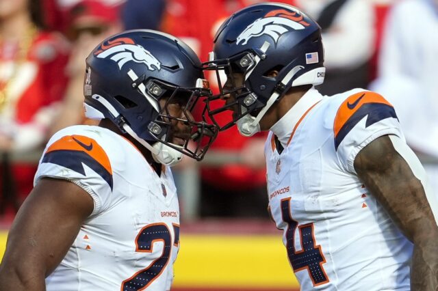 Audric Estime and Courtland Sutton celebrate with their helmets pushed together.