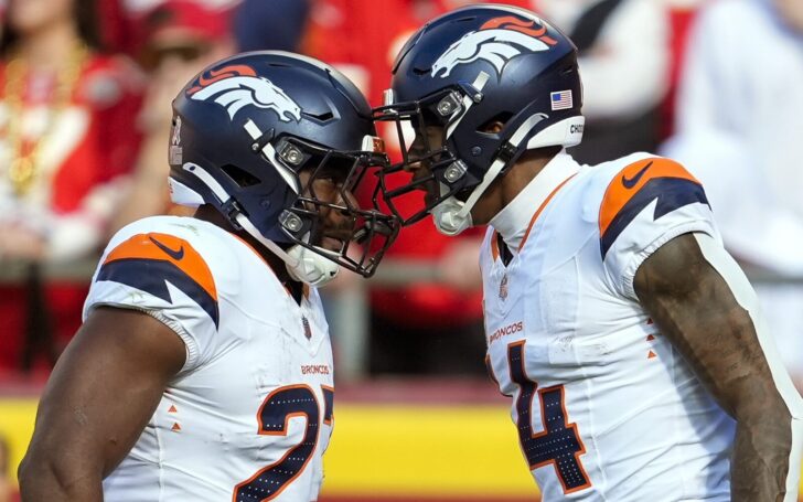 Audric Estime and Courtland Sutton celebrate with their helmets pushed together.