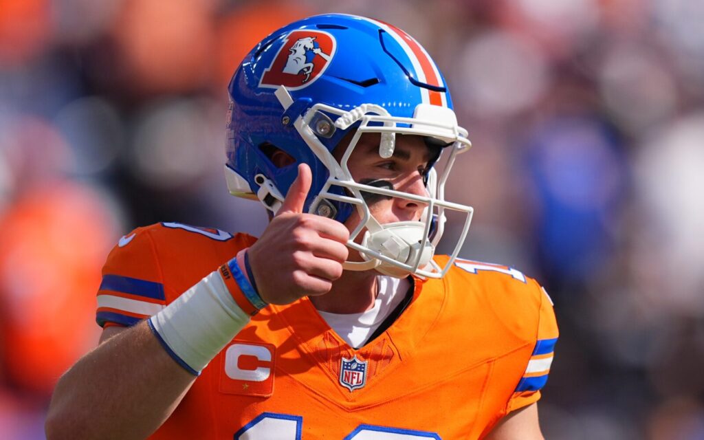 Bo Nix with the throwback Denver Broncos uniform on has a thumbs up.