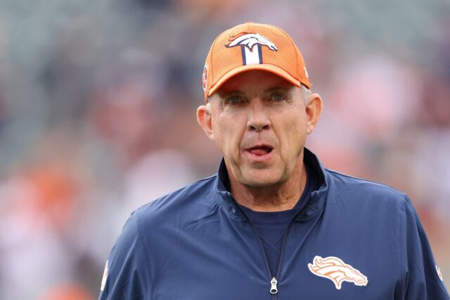 Sean Payton in an orange Broncos hat and blue zip up.