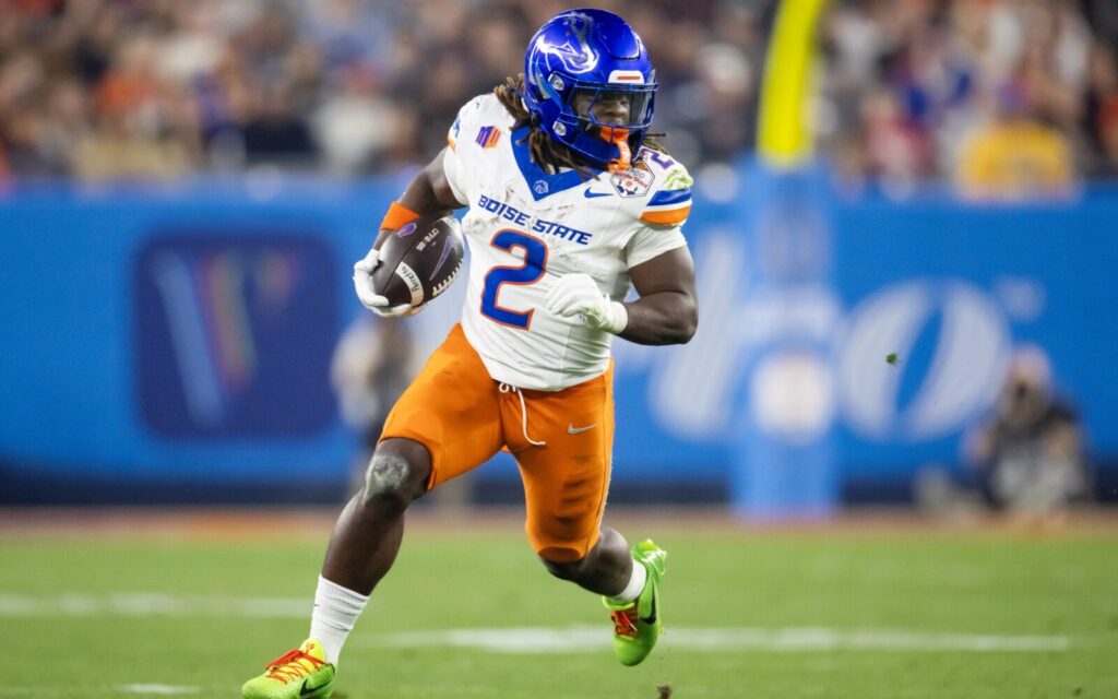 Ashton Jeanty in the Boise State Broncos white and orange uniform, runs on the field.