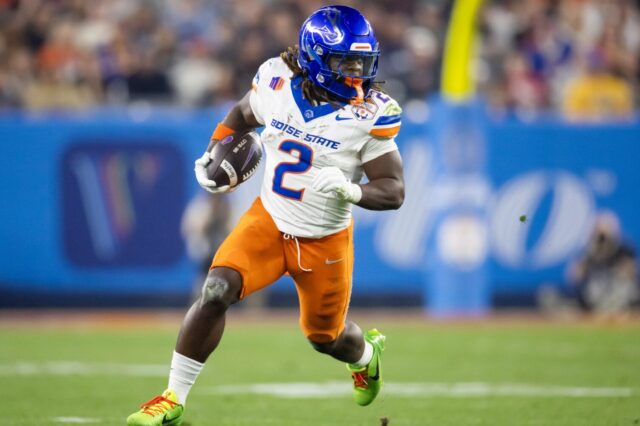 Ashton Jeanty in the Boise State Broncos white and orange uniform, runs on the field.