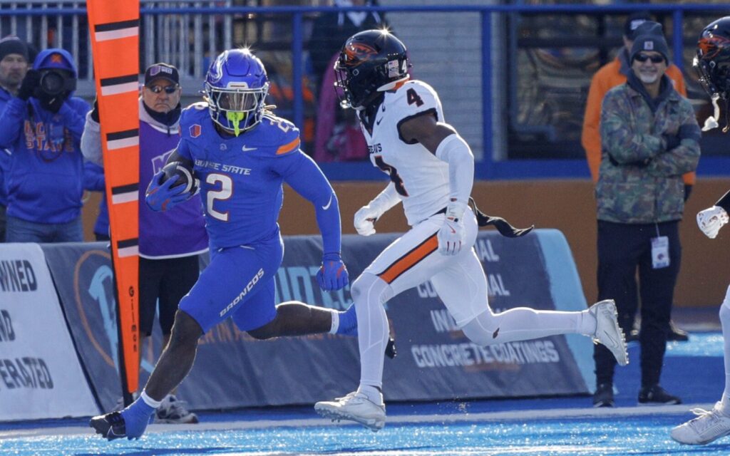 Ashton Jeanty runs next to a Washington State defender.