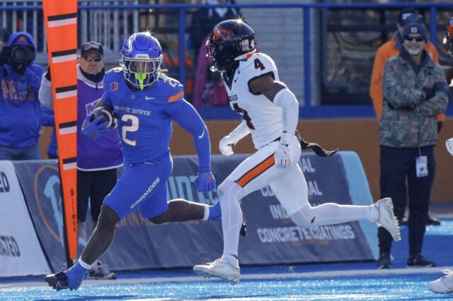 Ashton Jeanty runs next to a Washington State defender.