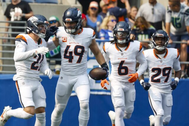 Alex Singleton celebrates intercepting a pass with teammates.