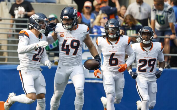 Alex Singleton celebrates intercepting a pass with teammates.