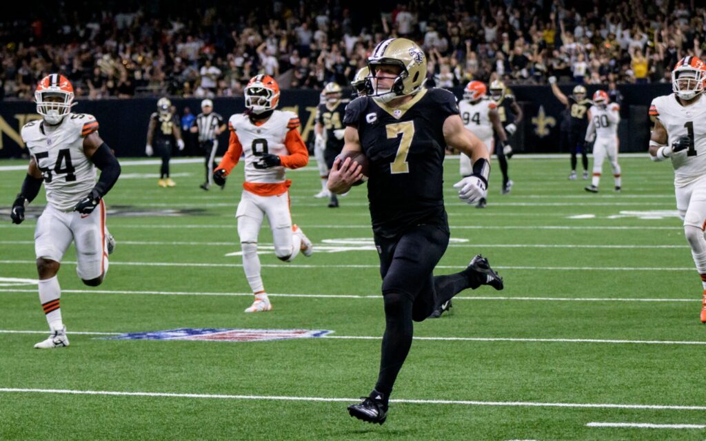 Taysom Hill runs for a touchdown. Five Cleveland Browns defenders are shown trailing him.