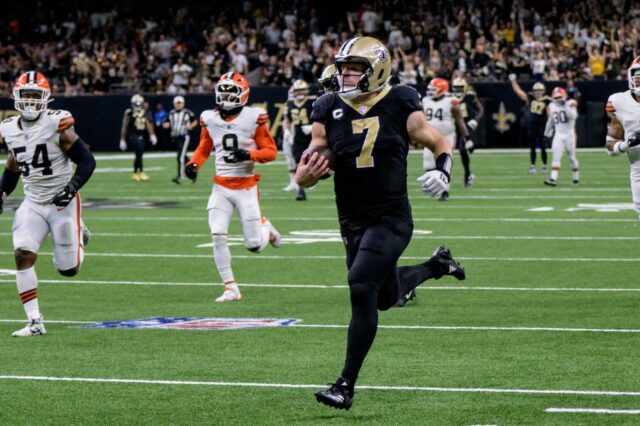 Taysom Hill runs for a touchdown. Five Cleveland Browns defenders are shown trailing him.