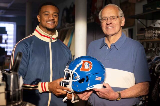 Pat Surtain II and Randy Gradishar pose with the Denver Broncos throwback helmet.