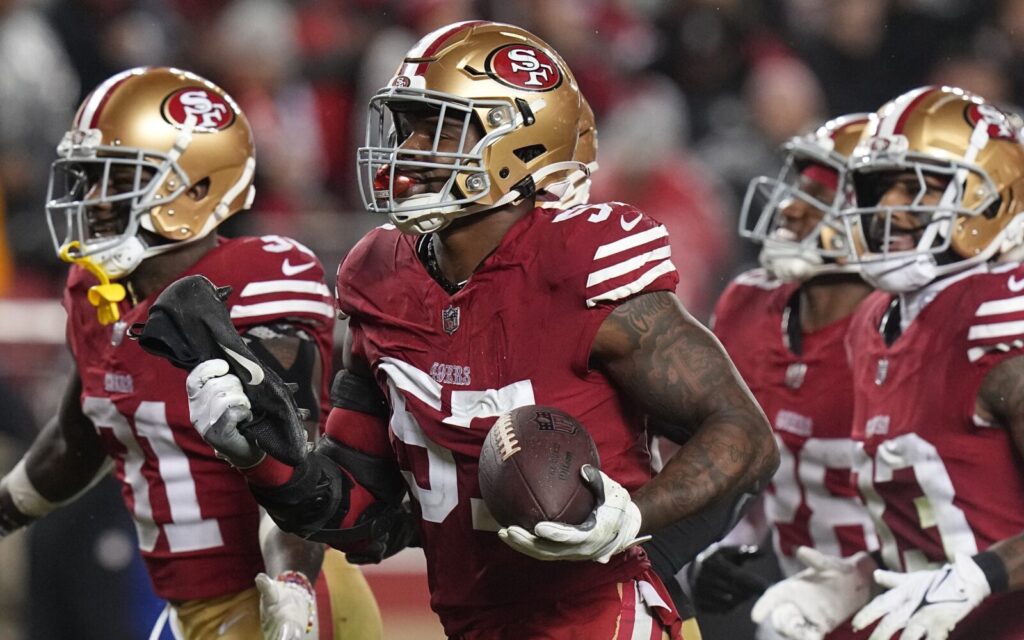 Dre Greenlaw, surrounded by three teammates with the 49ers.