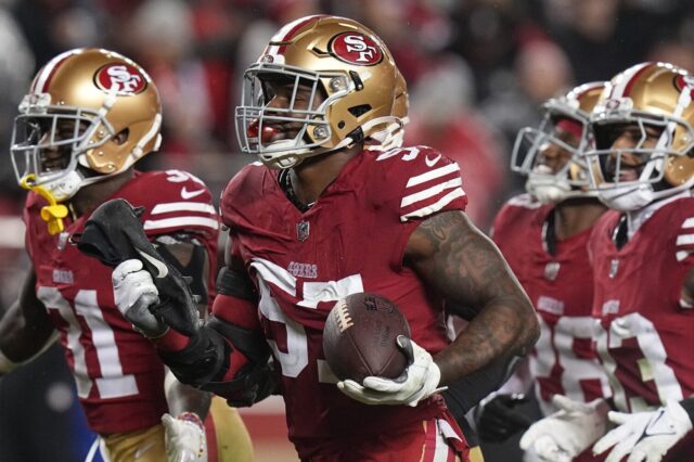 Dre Greenlaw, surrounded by three teammates with the 49ers.