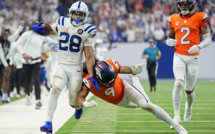 Jonathan Taylor runs and is knocked out of bounds by Talanoa Hufanga of the Broncos.