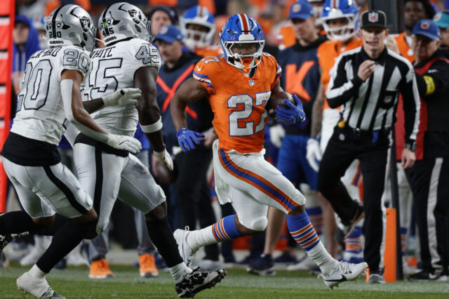 J.K. Dobbins runs against the Raiders.